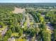 Aerial view of neighborhood featuring lush greenery, a tranquil lake, and various homes, suggesting a serene and well-planned community at 303 Sylvias Ct, Durham, NC 27703