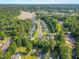 Aerial view of neighborhood featuring lush greenery, a tranquil lake, and various homes, suggesting a serene and well-planned community at 303 Sylvias Ct, Durham, NC 27703