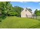Large backyard with a well-maintained lawn, mature trees, and a fence, creating a private outdoor space at 303 Sylvias Ct, Durham, NC 27703