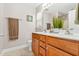 Well-lit bathroom features double sinks, wooden cabinetry, a large mirror, and neutral tile flooring at 303 Sylvias Ct, Durham, NC 27703