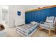 Cozy bedroom includes a blue panel wall, rocking chair, and a white dresser near an ensuite bath at 303 Sylvias Ct, Durham, NC 27703