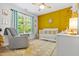 Inviting Bedroom features a cheerful yellow accent wall, white crib, soft rug, and comfortable rocking chair at 303 Sylvias Ct, Durham, NC 27703