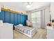 Stylish bedroom features a paneled blue wall, daybed, ceiling fan, and cozy rocking chair at 303 Sylvias Ct, Durham, NC 27703