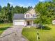 Charming two-story home with landscaped yard, inviting front porch, and an attached two-car garage at 303 Sylvias Ct, Durham, NC 27703