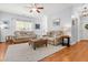 Bright living room featuring two sofas, an ottoman, ceiling fan, and hardwood floors covered by an area rug at 303 Sylvias Ct, Durham, NC 27703