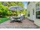 Outdoor patio with stone flooring, dining set with umbrella, and a fenced yard with mature trees at 303 Sylvias Ct, Durham, NC 27703