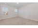 Cozy bedroom featuring neutral carpet, two windows with natural light, and freshly painted white walls at 311 Horseshoe Pl, Angier, NC 27501