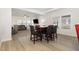 View of a dining area with a wooden table with seating for four and an open concept view into the living room at 311 Horseshoe Pl, Angier, NC 27501