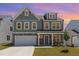 Charming two-story home featuring a stone facade, gray siding, and a well-manicured lawn at 311 Horseshoe Pl, Angier, NC 27501