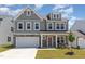 Charming two-story home with a stone facade, attached garage, and manicured lawn at 311 Horseshoe Pl, Angier, NC 27501