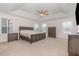 A view of the main bedroom with a large bed, ceiling fan, and several windows for natural light at 311 Horseshoe Pl, Angier, NC 27501