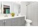 Renovated bathroom features dual vanity with neutral walls and a striped shower curtain at 318 Silverberry Ct, Cary, NC 27513
