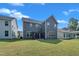 Rear view of a modern home showcasing a lush backyard and covered patio, ideal for entertaining at 325 Buckhorn Branch Park, Clayton, NC 27520