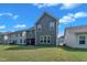 Backyard of a two-story gray home featuring a well-maintained lawn at 325 Buckhorn Branch Park, Clayton, NC 27520