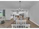 Open dining area with contemporary chandelier, modern kitchen, and wood-look flooring at 325 Buckhorn Branch Park, Clayton, NC 27520