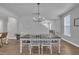 Dining area with hardwood floors and chandelier lighting, offering a glimpse of the staircase and window at 325 Buckhorn Branch Park, Clayton, NC 27520