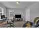 Bright home office features gray walls, carpet, a television, desk, and comfortable chair at 325 Buckhorn Branch Park, Clayton, NC 27520