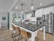 Modern kitchen featuring white cabinets, stainless steel appliances, and a large island with barstool seating at 325 Buckhorn Branch Park, Clayton, NC 27520