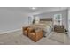 Large primary bedroom featuring tufted headboard, sitting area, neutral color palette, and plenty of windows at 325 Buckhorn Branch Park, Clayton, NC 27520