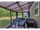 Covered outdoor patio featuring comfortable seating, a dining table, and a grill for outdoor entertaining at 325 Buckhorn Branch Park, Clayton, NC 27520