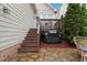 Backyard patio with grill and stairs up to the porch, ideal for outdoor cooking and dining at 327 Commons Walk Cir, Cary, NC 27519