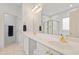 Bright bathroom with double vanity, white cabinets and large mirror at 327 Commons Walk Cir, Cary, NC 27519