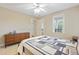 Comfortable bedroom features neutral walls, fan, a window for natural light, and a decorative quilt at 327 Commons Walk Cir, Cary, NC 27519