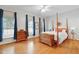 Bright bedroom with hardwood floors and elegant four-poster bed at 327 Commons Walk Cir, Cary, NC 27519