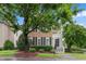 Charming brick home with black shutters, mature trees, and a welcoming front porch at 327 Commons Walk Cir, Cary, NC 27519