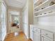 Hallway with wood floors, built-in shelving, and a view into a bedroom provides functionality and style at 327 Commons Walk Cir, Cary, NC 27519