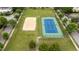 Aerial view of the community tennis and sand volleyball courts surrounded by lush green lawns and trees at 327 Commons Walk Cir, Cary, NC 27519