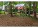 View of the home's backyard featuring mature trees and outdoor patio at 3285 Edinburgh Dr, Sanford, NC 27332