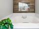 Bright bathroom with large tub and a beach themed print on the wall at 3285 Edinburgh Dr, Sanford, NC 27332