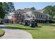 Charming clubhouse with a light brick base, large windows, covered balcony, and multiple golf carts at 3285 Edinburgh Dr, Sanford, NC 27332