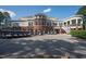 View of clubhouse highlighting brick base, multiple windows, staircase, and convenient golf cart parking at 3285 Edinburgh Dr, Sanford, NC 27332