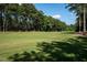 Wide golf course view with healthy green grass, bordered by mature trees in a beautiful neighborhood at 3285 Edinburgh Dr, Sanford, NC 27332