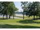 Picturesque golf course view featuring lush green grass, mature trees, and a glimpse of the lake at 3285 Edinburgh Dr, Sanford, NC 27332