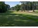 Lush green golf course view featuring cart path, mature trees, and well-placed sand traps at 3285 Edinburgh Dr, Sanford, NC 27332