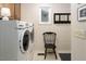 Functional laundry room with modern washer and dryer, stylish chair, and practical storage solutions at 3285 Edinburgh Dr, Sanford, NC 27332