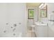 Bright bathroom with floral tile accents, a tub/shower combo, and a window for natural light at 330 Wilmot Dr, Raleigh, NC 27606