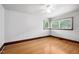 Sunlit bedroom with hardwood floors and a large window offering backyard views at 330 Wilmot Dr, Raleigh, NC 27606
