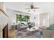 Staged living room with neutral furniture, fireplace, and views to a lush backyard at 330 Wilmot Dr, Raleigh, NC 27606