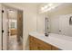 Bathroom with warm cabinetry, quartz countertop, and view to the bathtub at 3728 Westbury Lake Dr, Raleigh, NC 27603