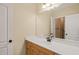 Bathroom with warm cabinetry, quartz countertop, and mirror at 3728 Westbury Lake Dr, Raleigh, NC 27603