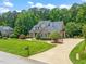 Beautiful home with manicured front lawn, mature trees, and a circular driveway at 3728 Westbury Lake Dr, Raleigh, NC 27603