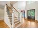 Elegant foyer with hardwood floors, staircase, and a view of the front door and living spaces at 3728 Westbury Lake Dr, Raleigh, NC 27603