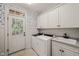The laundry room features a washer, dryer, sink, lots of cabinet space and patterned wallpaper at 3728 Westbury Lake Dr, Raleigh, NC 27603