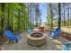 Backyard area with outdoor seating and a fire pit in a wooded area at 374 Heart Pine Dr, Wendell, NC 27591
