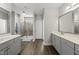 Bright bathroom featuring double vanities, a modern shower, and wood-look floors at 374 Heart Pine Dr, Wendell, NC 27591