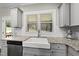 Kitchen featuring granite countertops, stainless dishwasher, and a white farmhouse sink at 374 Heart Pine Dr, Wendell, NC 27591
